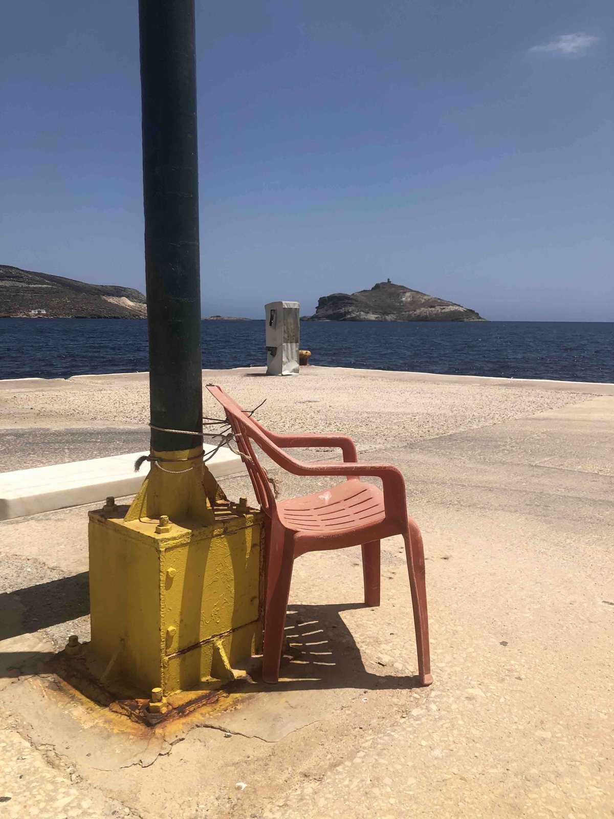 Chaise en plastique enchaînée face à la mer Égée, Tinos